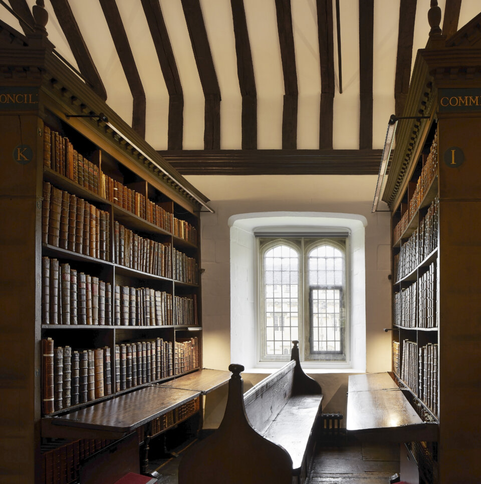 Historic bookshelves on either side of a bench and window