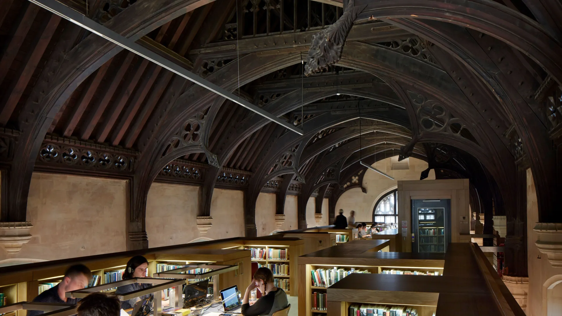 Top floor of Magdalen College Library beneath the exposed historic timber ceiling