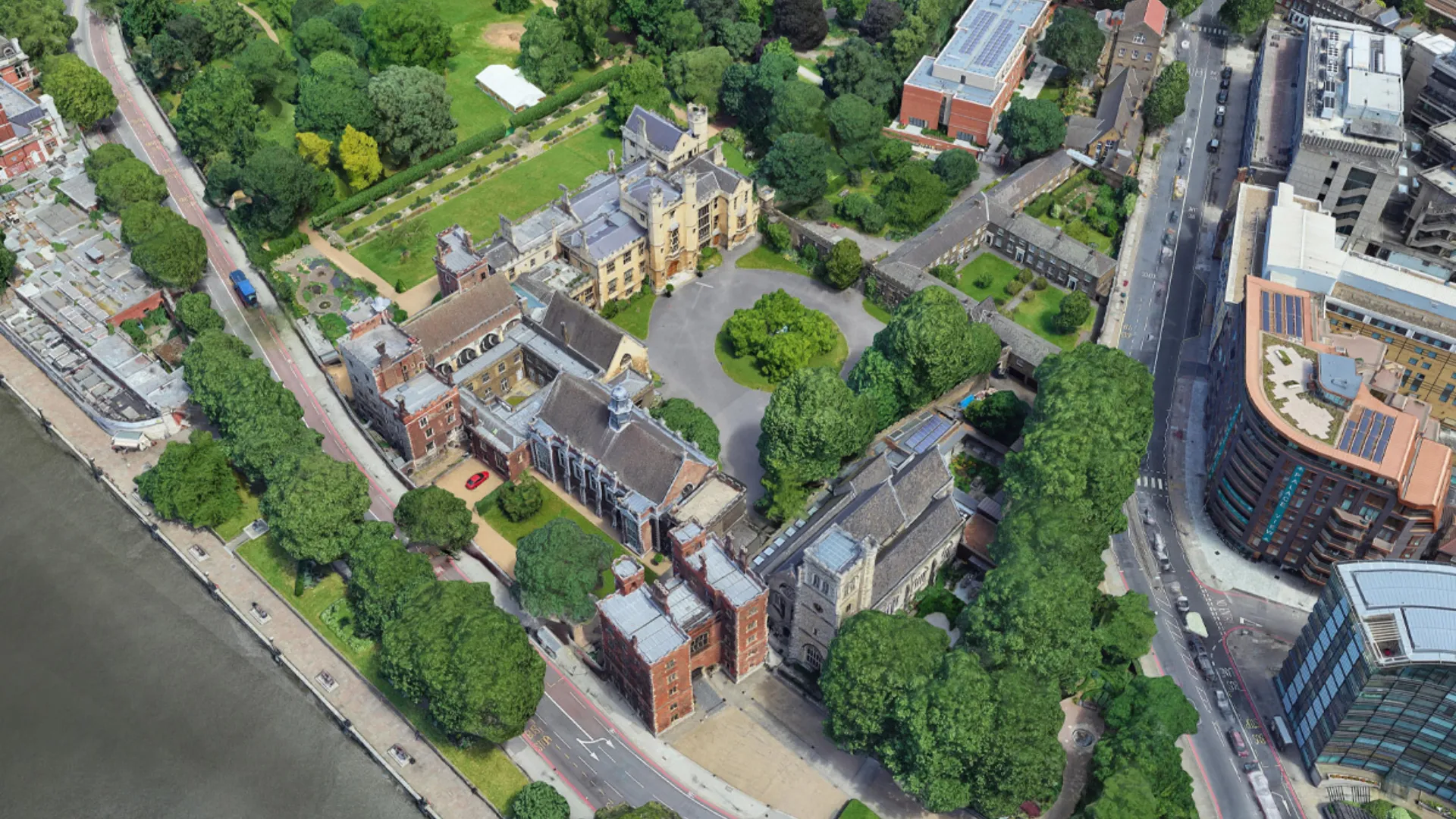 Aerial view of Lambeth Palace in London showing several brick and stone buildings and green spaces situated to the south of the River Thames
