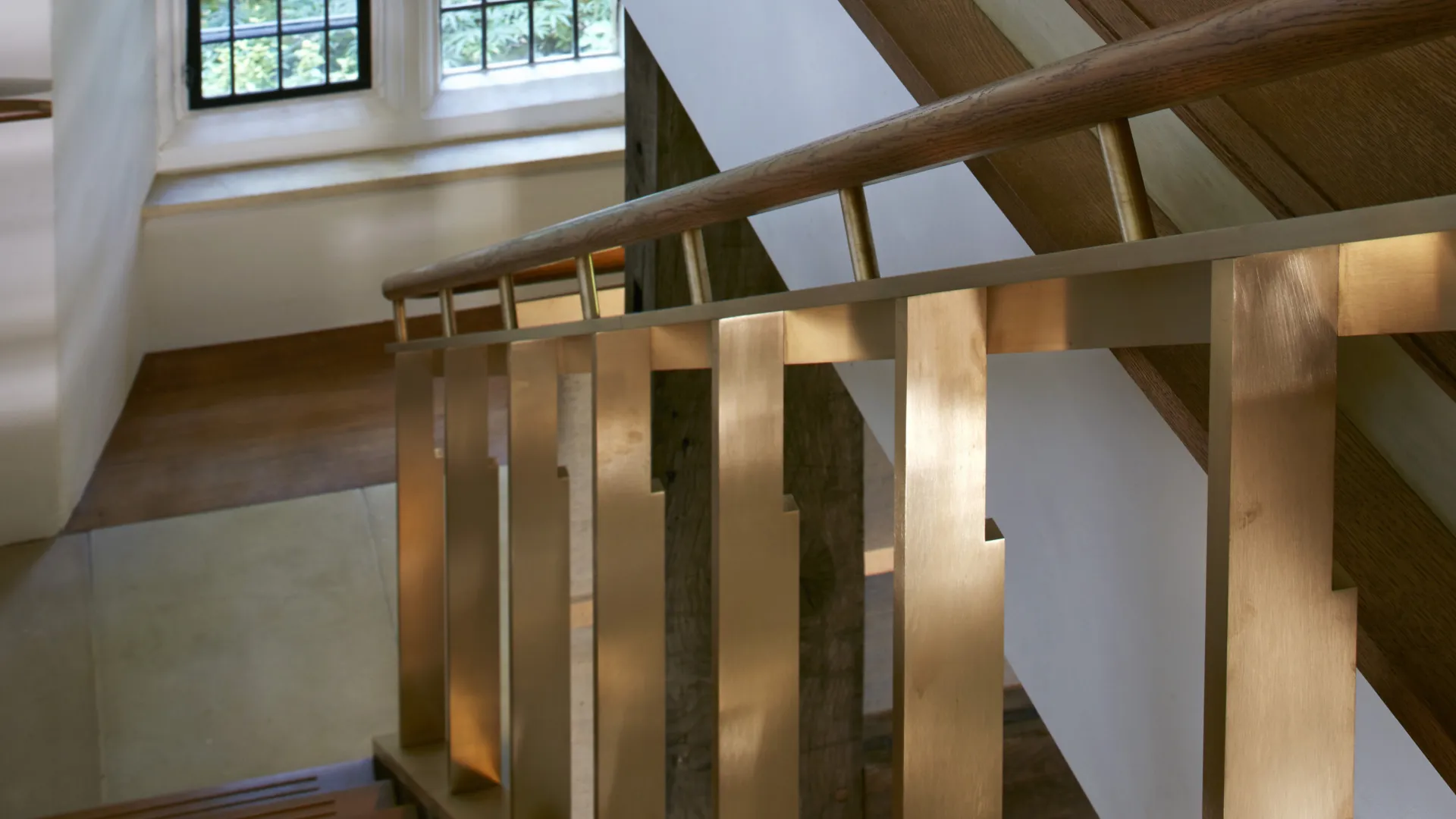 A modern stair set within historic timber beamed space.