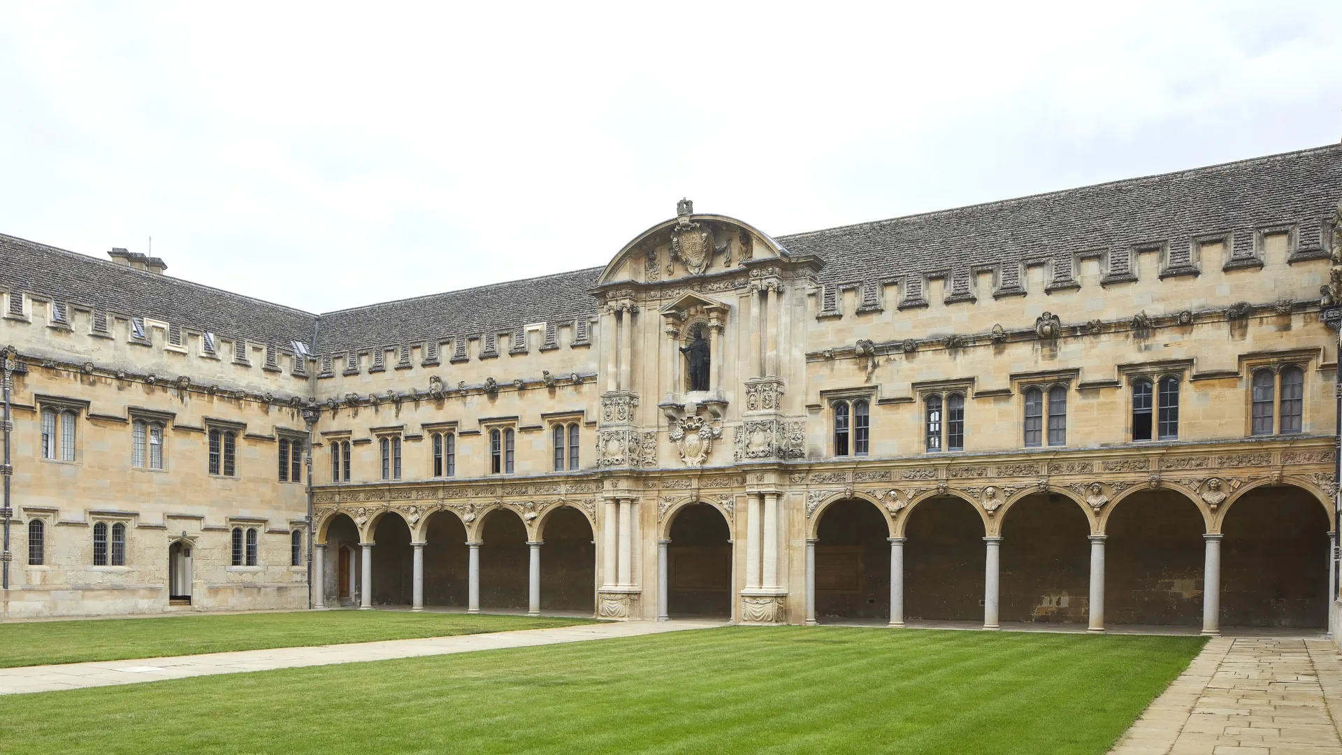 Stone quadrangle with several buildings arranged in a square around a green lawn