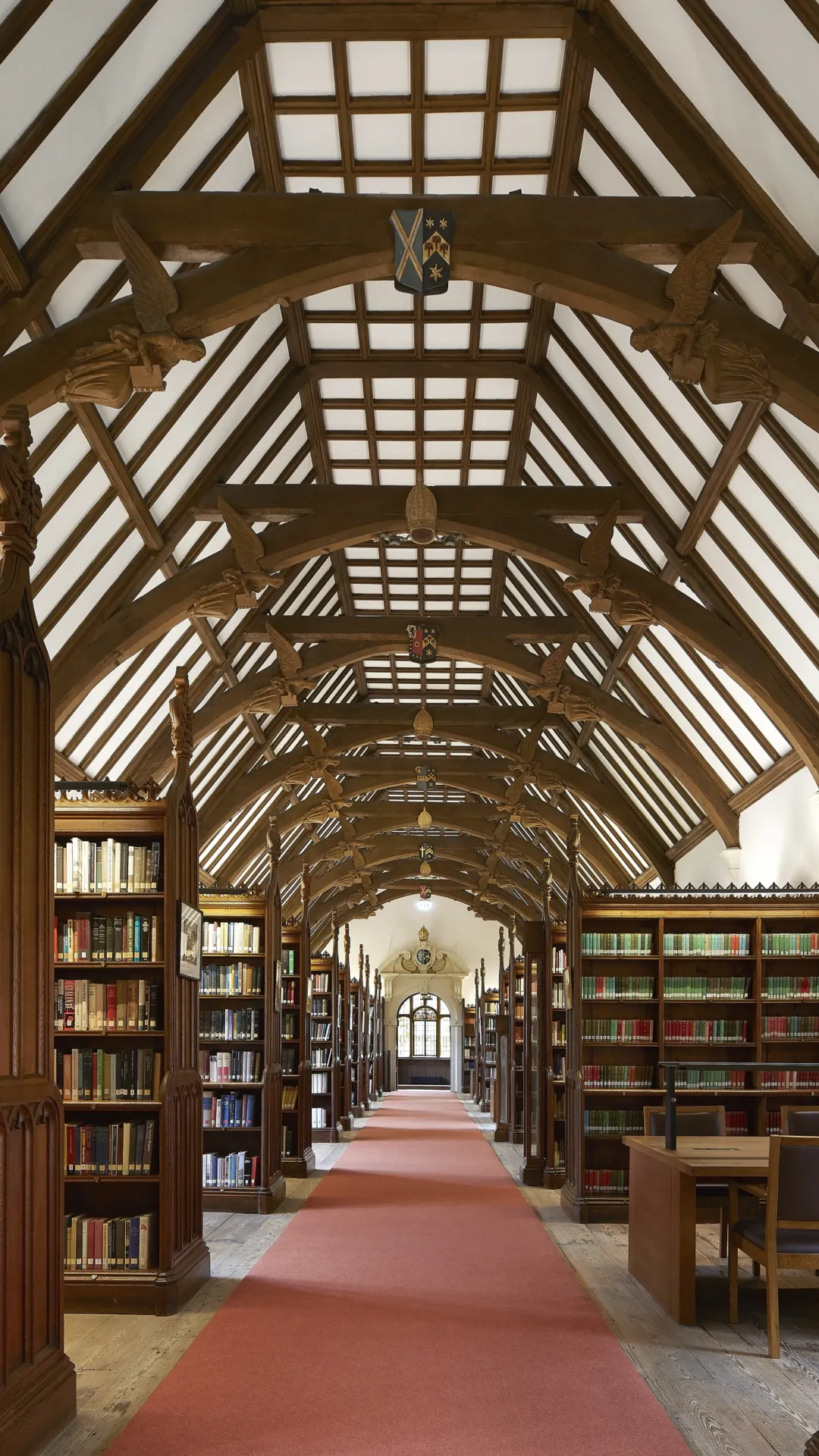 Interior of a historic library with wooden vaulted ceiling and bookshelves