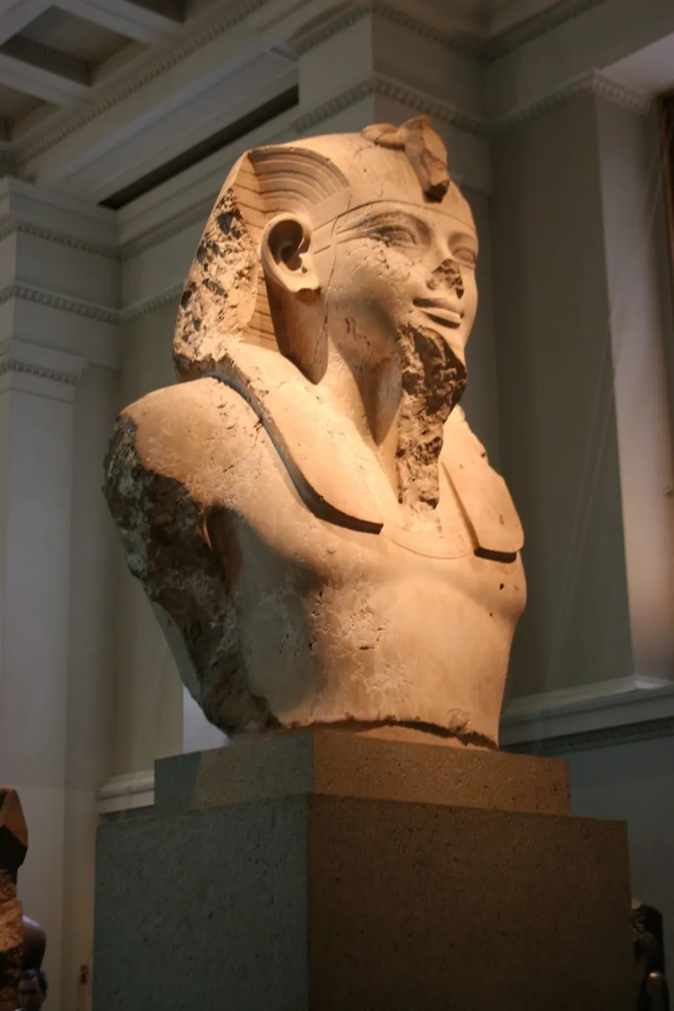 Side view of a sculpture of Amenhotep III on a pedestal in the galleries of Ancient Egyptian Art at the British Museum