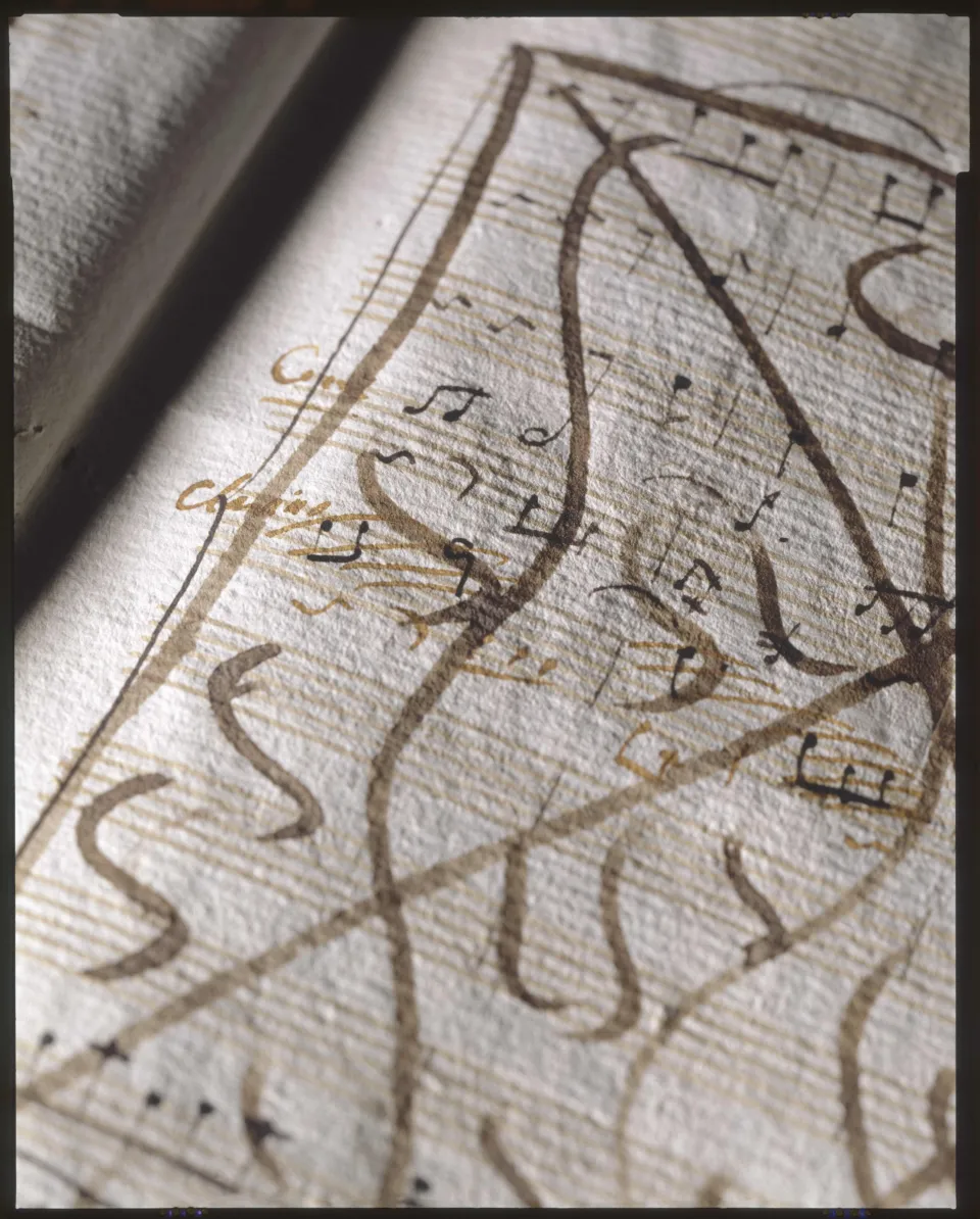 Annotated ancient musical manuscript with brown ink markings