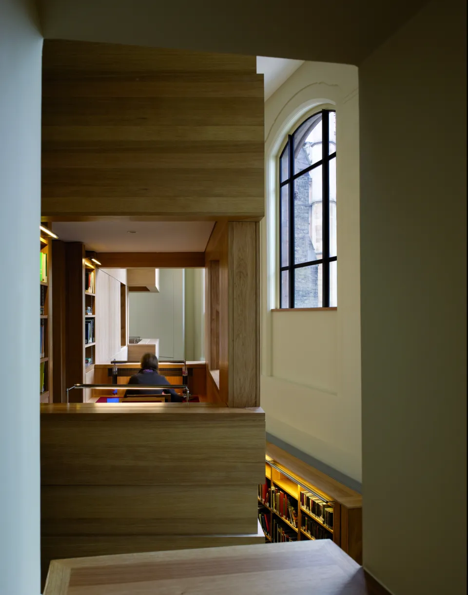 Student studying and looking into atrium in the Taylor Library at Corpus Christi College Cambridge