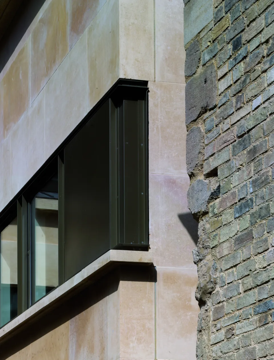 New stone and window against historic masonry wall at Corpus Christi College Cambridge