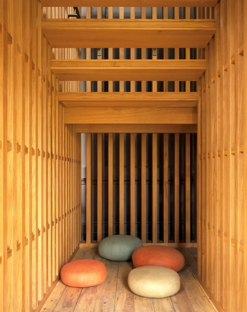Area beneath a contemporary oak stairwell with four floor cushions