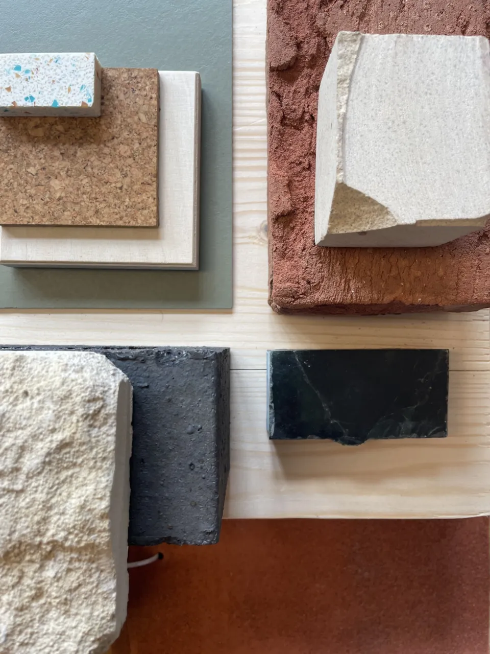 A range of material samples including brick, stone and cork arranged on a table.