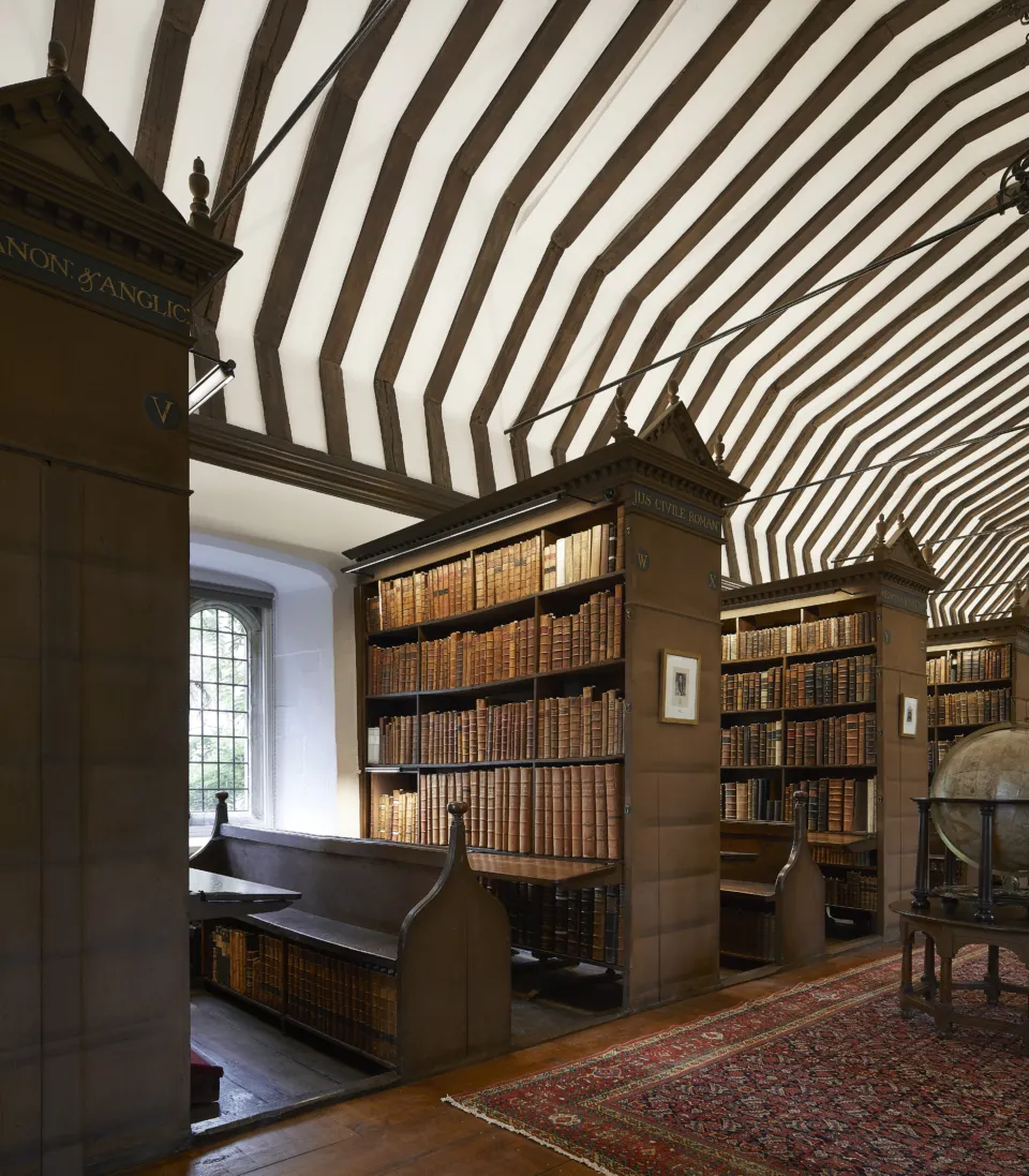 historic library with wooden bookshelves and beamed ceilings