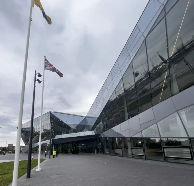 glass building with two flagpoles at left
