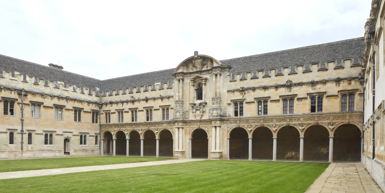 Stone quadrangle with several buildings arranged in a square around a green lawn