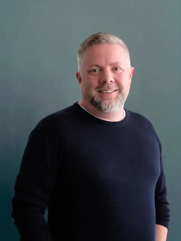 Portrait image of a man wearing a dark blue jumper